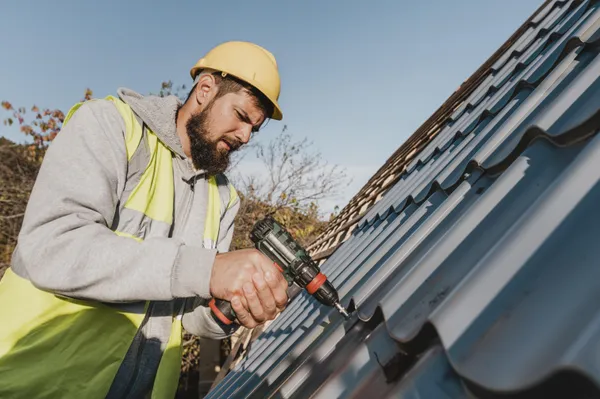Man Working Roof With Drill